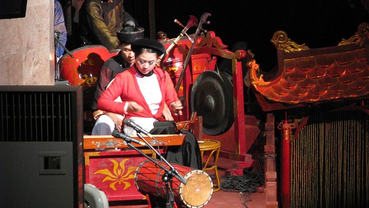 Musicians performing beside a traditional Vietnamese water puppet stage